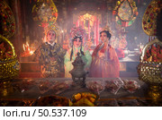 Male and female Chinese opera actors Light a candle to pray homage to the gods to enhance the prosperity for yourself on the occasion of the Chinese New Year festival. Стоковое фото, агентство Ingram Publishing / Фотобанк Лори