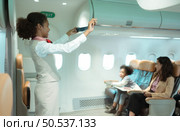 Flight attendants show how to use safety devices and recommend emergency exits. Стоковое фото, агентство Ingram Publishing / Фотобанк Лори