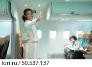 Flight attendants show how to use safety devices and recommend emergency exits. Стоковое фото, агентство Ingram Publishing / Фотобанк Лори