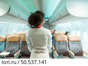 Flight attendants show how to use safety devices and recommend emergency exits. Стоковое фото, агентство Ingram Publishing / Фотобанк Лори