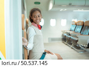 Flight attendant speaking through a loudspeaker to welcome passengers and give advice on traveling by plane. Стоковое фото, агентство Ingram Publishing / Фотобанк Лори