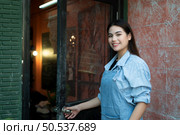 A young businesswoman who owns a pottery school Open the door to welcome students who love to learn pottery. Стоковое фото, агентство Ingram Publishing / Фотобанк Лори