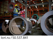 Two technicians Inspecting and testing the operation of lifting cranes in heavy industrial plants. Стоковое фото, агентство Ingram Publishing / Фотобанк Лори