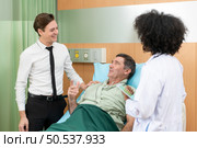 A young female doctor who specializes in heart disease. Advise patients with heart disease symptoms and the patient’s son. that the results of the treatment improved until they were able to go home tomorrow. Стоковое фото, агентство Ingram Publishing / Фотобанк Лори