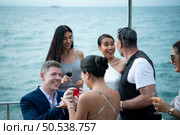 The appropriate time for a white man to propose to marry an Asian woman. on a yacht floating in the lovely water. Among friends who joined in congratulating. Стоковое фото, агентство Ingram Publishing / Фотобанк Лори