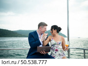 On a yacht, a businessman begins his family’s vacation. a huge project agreement was successfully closed, which was wonderful news. Стоковое фото, агентство Ingram Publishing / Фотобанк Лори