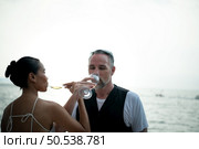 Happy moments of interracial couples on a yacht The couple had their honeymoon at one of Asia’s most beautiful seas. Стоковое фото, агентство Ingram Publishing / Фотобанк Лори