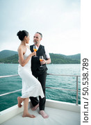 Happy moments of interracial couples on a yacht The couple had their honeymoon at one of Asia’s most beautiful seas. Стоковое фото, агентство Ingram Publishing / Фотобанк Лори