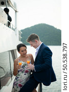 Happy moments of interracial couples on a yacht The couple had their honeymoon at one of Asia’s most beautiful seas. Стоковое фото, агентство Ingram Publishing / Фотобанк Лори