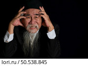 Portrait of a wrinkled-faced old man with a long white beard on a black background, studio shot. Стоковое фото, агентство Ingram Publishing / Фотобанк Лори