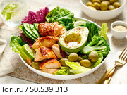 Salmon avocado bowl with broccoli, olives and fresh salad. Healthy food, keto diet. Стоковое фото, агентство Ingram Publishing / Фотобанк Лори