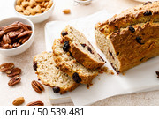 Fruitcake with cranberry, almond and pecan nuts sliced on a wooden board. Стоковое фото, агентство Ingram Publishing / Фотобанк Лори