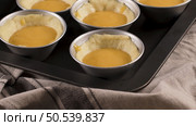Egg tarts, traditional portuguese dessert, pastel de nata, custard tarts during home production on metal tray. Стоковое фото, агентство Ingram Publishing / Фотобанк Лори