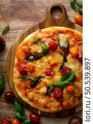 Pizza Margherita on a wooden background. Стоковое фото, агентство Ingram Publishing / Фотобанк Лори