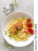 Couscous with chicken patties, cutlets and tomatoes, top down view. Стоковое фото, агентство Ingram Publishing / Фотобанк Лори