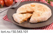 Italian food, pizza calzone with tomato, spinach and cheese on wooden background. Стоковое фото, агентство Ingram Publishing / Фотобанк Лори
