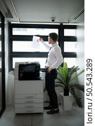 Businessman in office working with copier. Стоковое фото, агентство Ingram Publishing / Фотобанк Лори