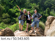 Group of tourists with backpacks walking on the trail in the river and mountains. Стоковое фото, агентство Ingram Publishing / Фотобанк Лори