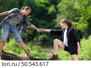 Young couple hiking in the forest with backpacks and trekking poles. Стоковое фото, агентство Ingram Publishing / Фотобанк Лори