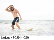 Young man surfing on the beach having fun and balancing on the surfboard. Стоковое фото, агентство Ingram Publishing / Фотобанк Лори