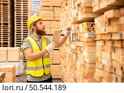 Portrait of warehouse worker checking stock of wooden pallets in storage warehouse. Стоковое фото, агентство Ingram Publishing / Фотобанк Лори