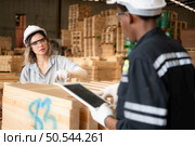 Young female and male warehouse workers using digital tablet for working in wooden factory, Checking the neatness of the planks. Стоковое фото, агентство Ingram Publishing / Фотобанк Лори