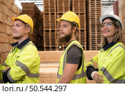 Group of workers in a large timber factory, Have fun by raising your arms after completing the day’s work. Стоковое фото, агентство Ingram Publishing / Фотобанк Лори