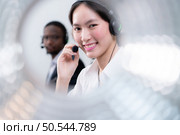 Group of business people wearing headset working actively in office. Call center, telemarketing, customer support agent provide service on telephone video conference call. Стоковое фото, агентство Ingram Publishing / Фотобанк Лори