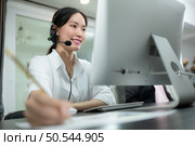 Portrait of business people wearing headset working actively in office. Call center, telemarketing, customer support agent provide service on telephone video conference call. Стоковое фото, агентство Ingram Publishing / Фотобанк Лори