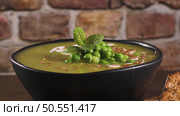 Green pea soup with linseed and pumpkin and sunflower seeds on a rustic kitchen countertop. Стоковое фото, агентство Ingram Publishing / Фотобанк Лори