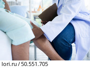 Doctor examining knee joint function of patient in hospital, Medical health care. Стоковое фото, агентство Ingram Publishing / Фотобанк Лори