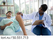 Doctor examining knee joint function of patient in hospital, Medical health care. Стоковое фото, агентство Ingram Publishing / Фотобанк Лори