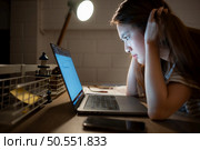 A young woman works on her laptop at home. It is characterized with headaches that occur when stressed. Стоковое фото, агентство Ingram Publishing / Фотобанк Лори