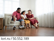 A plus size family with a father wearing a prosthetic leg, Give a gift to a daughter who does well in school and receives acclaim from her teachers, in the living room of the house. Стоковое фото, агентство Ingram Publishing / Фотобанк Лори