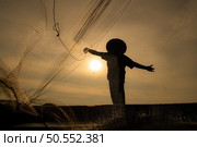 Silhouette of fisherman at sunrise, Standing aboard a rowing boat and casting a net to catch fish for food. Стоковое фото, агентство Ingram Publishing / Фотобанк Лори