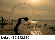 Silhouette of a fisherman in the water at sunset, Thailand. Стоковое фото, агентство Ingram Publishing / Фотобанк Лори