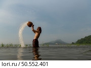 Fishermen using traditional fishing equipment After catching fish, clean up and play in the water. Стоковое фото, агентство Ingram Publishing / Фотобанк Лори