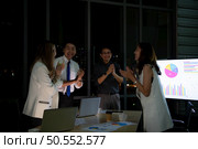 Group of broker international stock traders working actively at night in office, Everyone is congratulating the team on their success. Стоковое фото, агентство Ingram Publishing / Фотобанк Лори