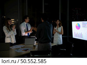 Group of broker international stock traders working actively at night in office, Everyone is congratulating the team on their success. Стоковое фото, агентство Ingram Publishing / Фотобанк Лори