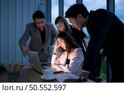 Group of broker international stock traders working actively at night in office, A young woman is working hustle to present a client with friends helping her with information. Стоковое фото, агентство Ingram Publishing / Фотобанк Лори