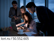 Group of broker international stock traders working actively at night in office, A young woman is working hustle to present a client with friends helping her with information. Стоковое фото, агентство Ingram Publishing / Фотобанк Лори