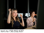Young Asian woman broker international stock traders wearing headset working actively at night in office, Concept of customer support agent provide service on telephone. Стоковое фото, агентство Ingram Publishing / Фотобанк Лори