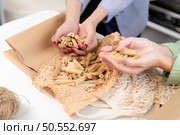 Young Asian businesswoman Clothes are being packaged for delivery to customers in cardboard boxes and cushioned lump from natural materials that are not toxic to the planet. Стоковое фото, агентство Ingram Publishing / Фотобанк Лори