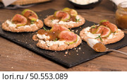 Canape or crostini with multigrain  crispread with cream cheese and fig jam on a slate board. Delicious appetizer ideal as an aperitif. Стоковое фото, агентство Ingram Publishing / Фотобанк Лори