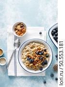 Oatmeal porridge with blueberry, almonds, walnuts, flax seeds, sesame and chia. Healthy vegetarian food for breakfast, top down view. Стоковое фото, агентство Ingram Publishing / Фотобанк Лори