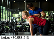 Young couples work out at the gym to strengthen the body. Each person recommends exercise for each other and encourage each other while exercising. Стоковое фото, агентство Ingram Publishing / Фотобанк Лори