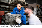 Two men repairing car engine in auto repair shop, Selective focus. Стоковое фото, агентство Ingram Publishing / Фотобанк Лори