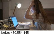 A young woman works on her laptop at home. It is characterized with headaches that occur when stressed. Стоковое фото, агентство Ingram Publishing / Фотобанк Лори