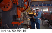 Engineer and technician discussing machinery in factory to plan inspection maintenance according to usage cycle, Concepts inspections based on usage cycle maintenance. Стоковое фото, агентство Ingram Publishing / Фотобанк Лори