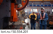 Engineer and technician discussing machinery in factory to plan inspection maintenance according to usage cycle, Concepts inspections based on usage cycle maintenance. Стоковое фото, агентство Ingram Publishing / Фотобанк Лори